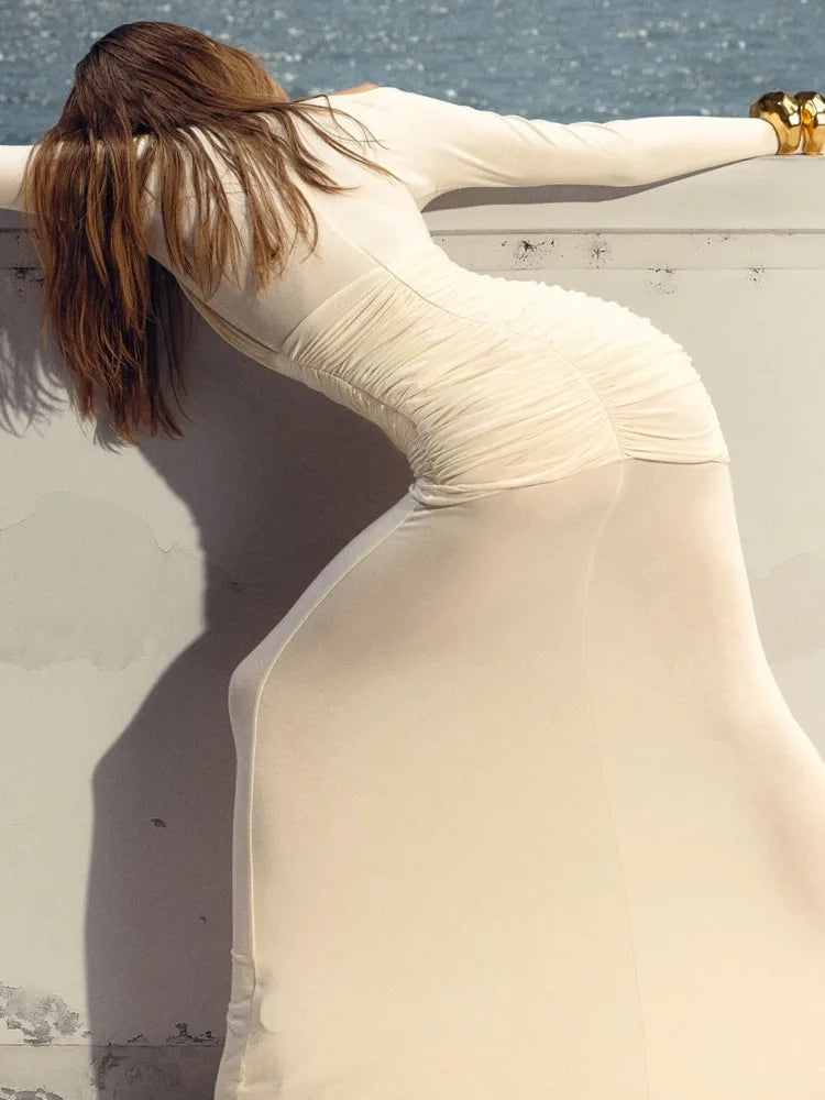 An elegant, figure-hugging, sexy, double-layered, sheer-look, long-sleeved party, club, and evening dress with mesh and patch details.